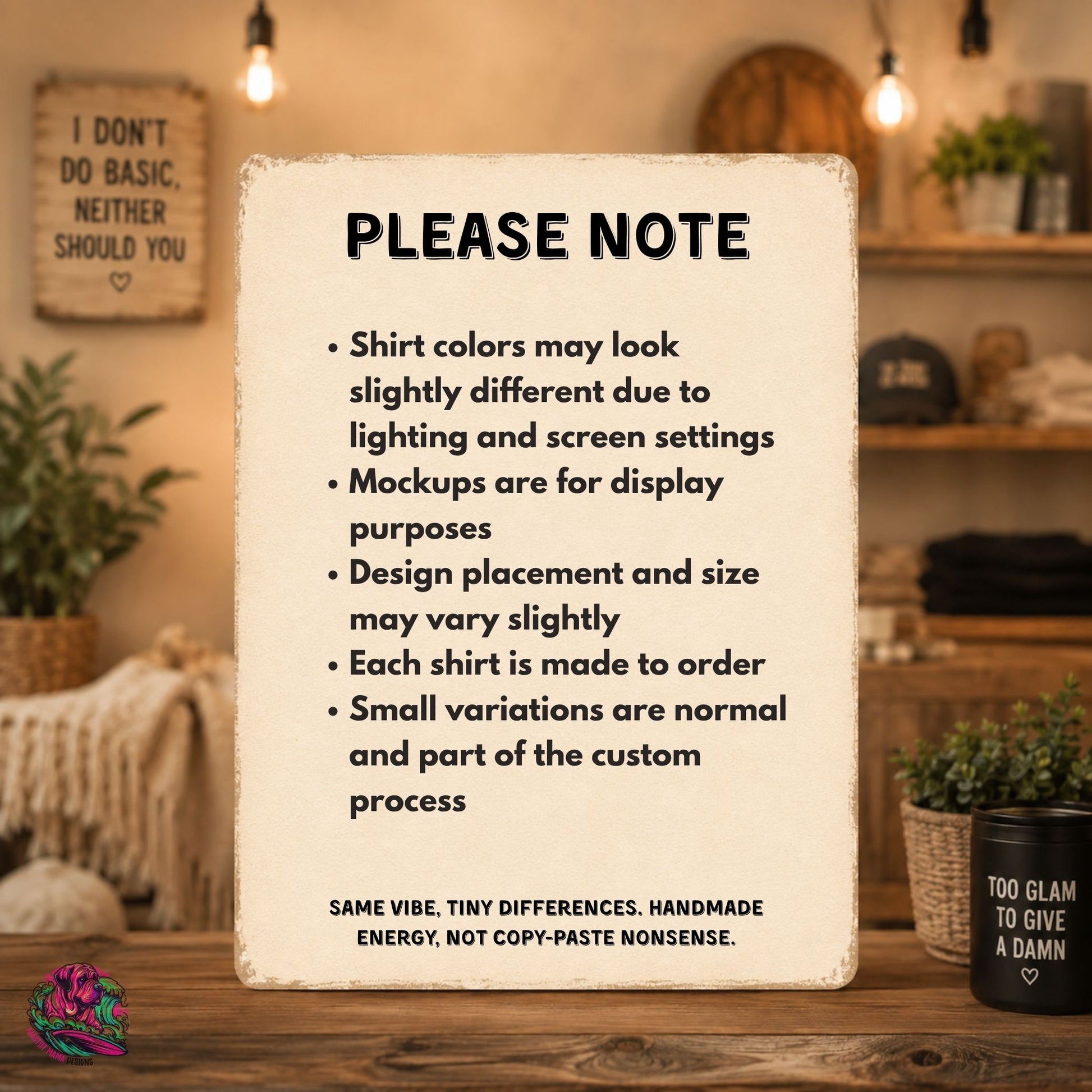 A rectangular printed note with rounded corners stands on a wooden table in a styled room. The note reads “PLEASE NOTE” with bullet points about shirt color differences, mockup purposes, design placement, custom making, and small variations.