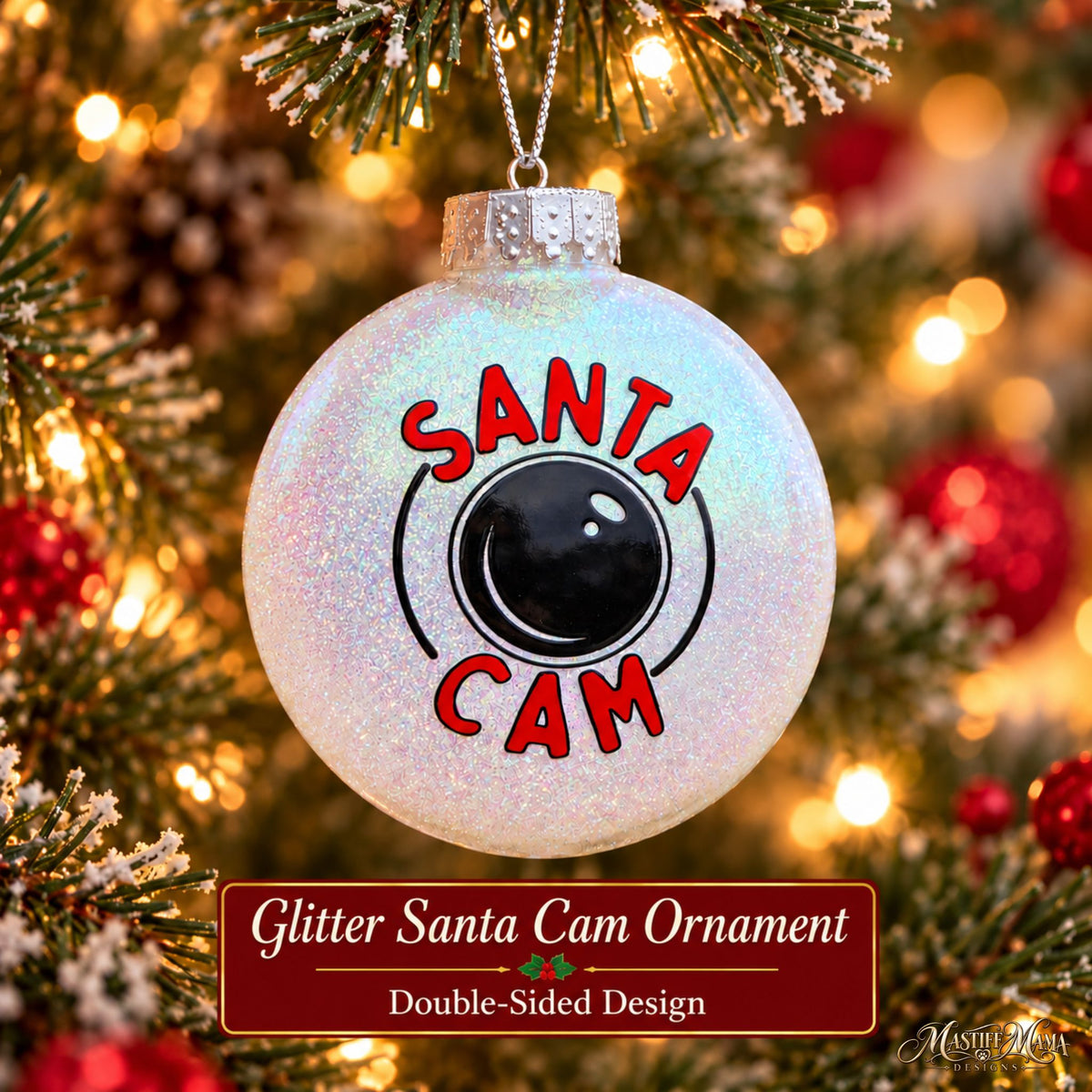 Handmade glitter Santa Cam plastic Christmas ornament with red lettering and a black camera design hanging from a holiday tree.
