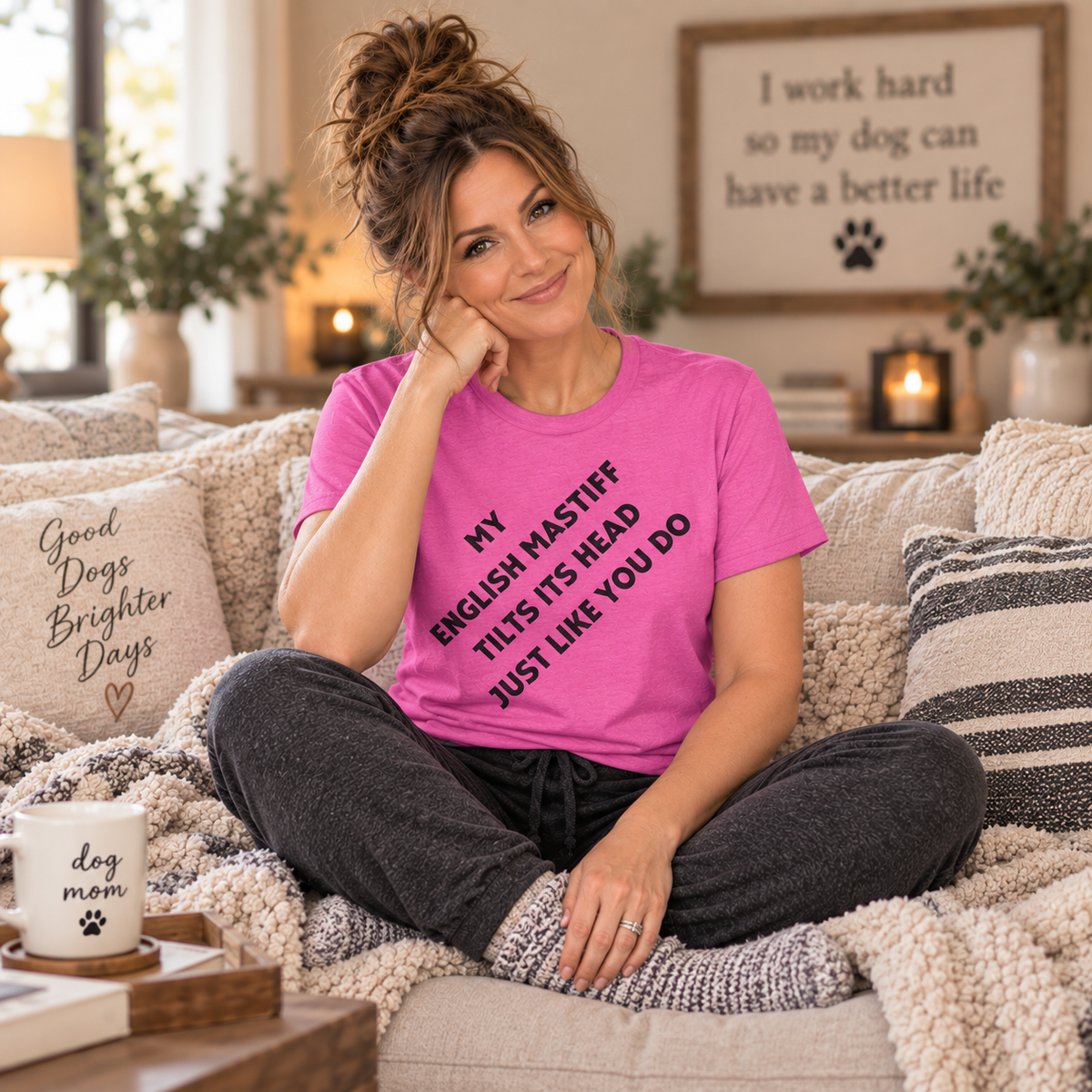  Woman wearing a pink English Mastiff head tilt t-shirt while sitting on a cozy couch.